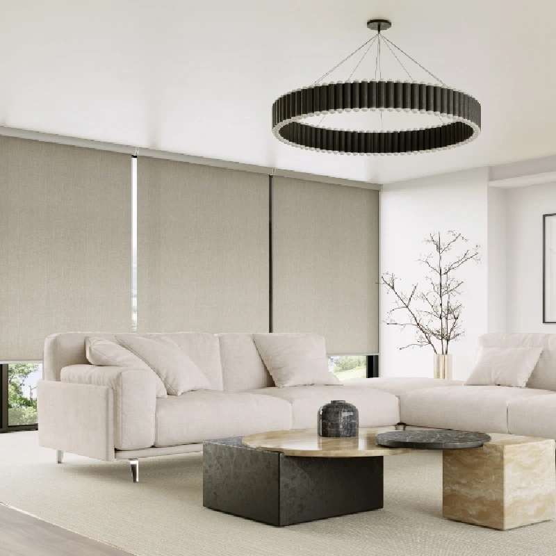 Large beige motorized roller blinds fully lowered in a modern living room