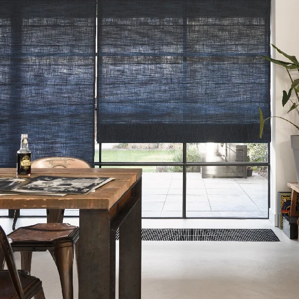 Modern dining area featuring textured blue motorized Roman blinds